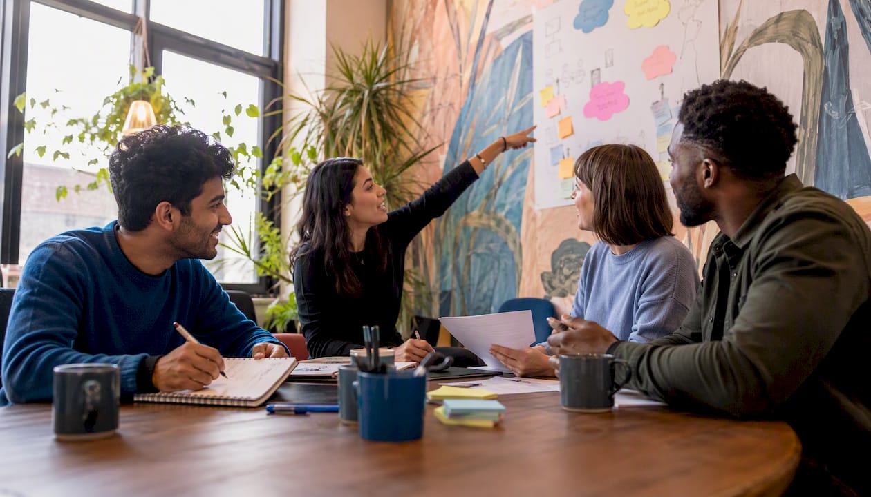 Diverse team brainstorming next to whiteboard