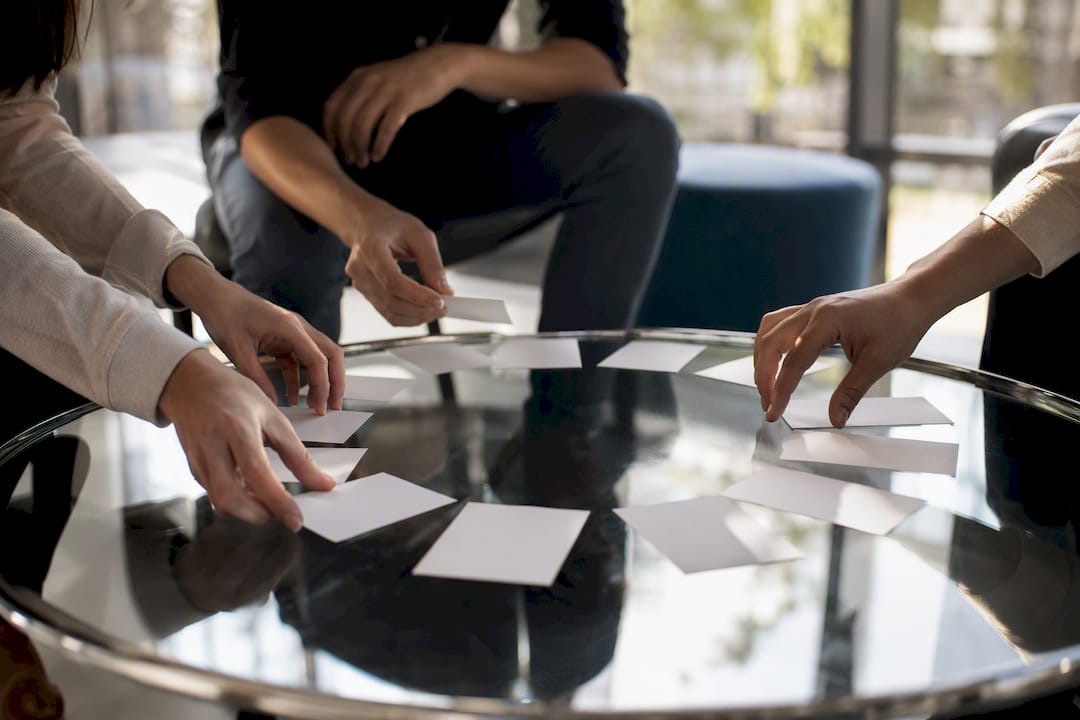 Hands rearranging cards symbolizing psychological safety