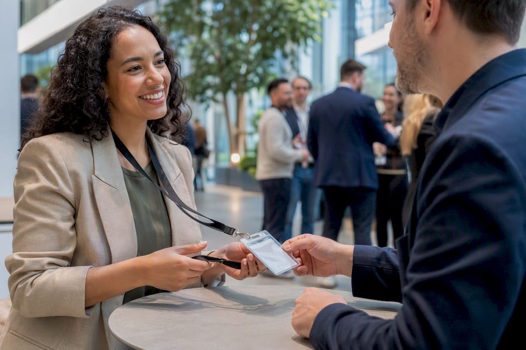 Hands exchanging event badges at networking