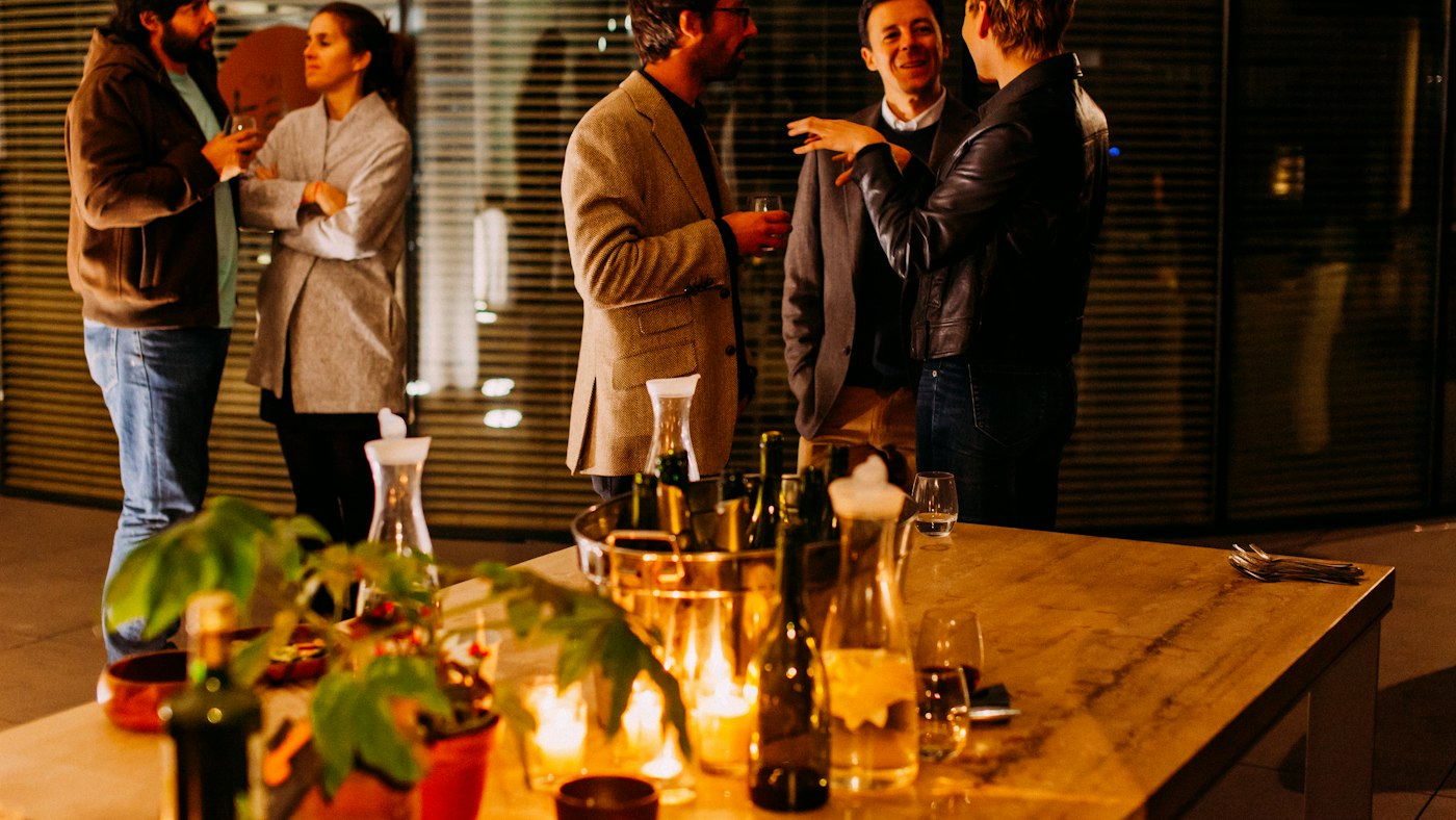 Five people standing and talking at a professional event